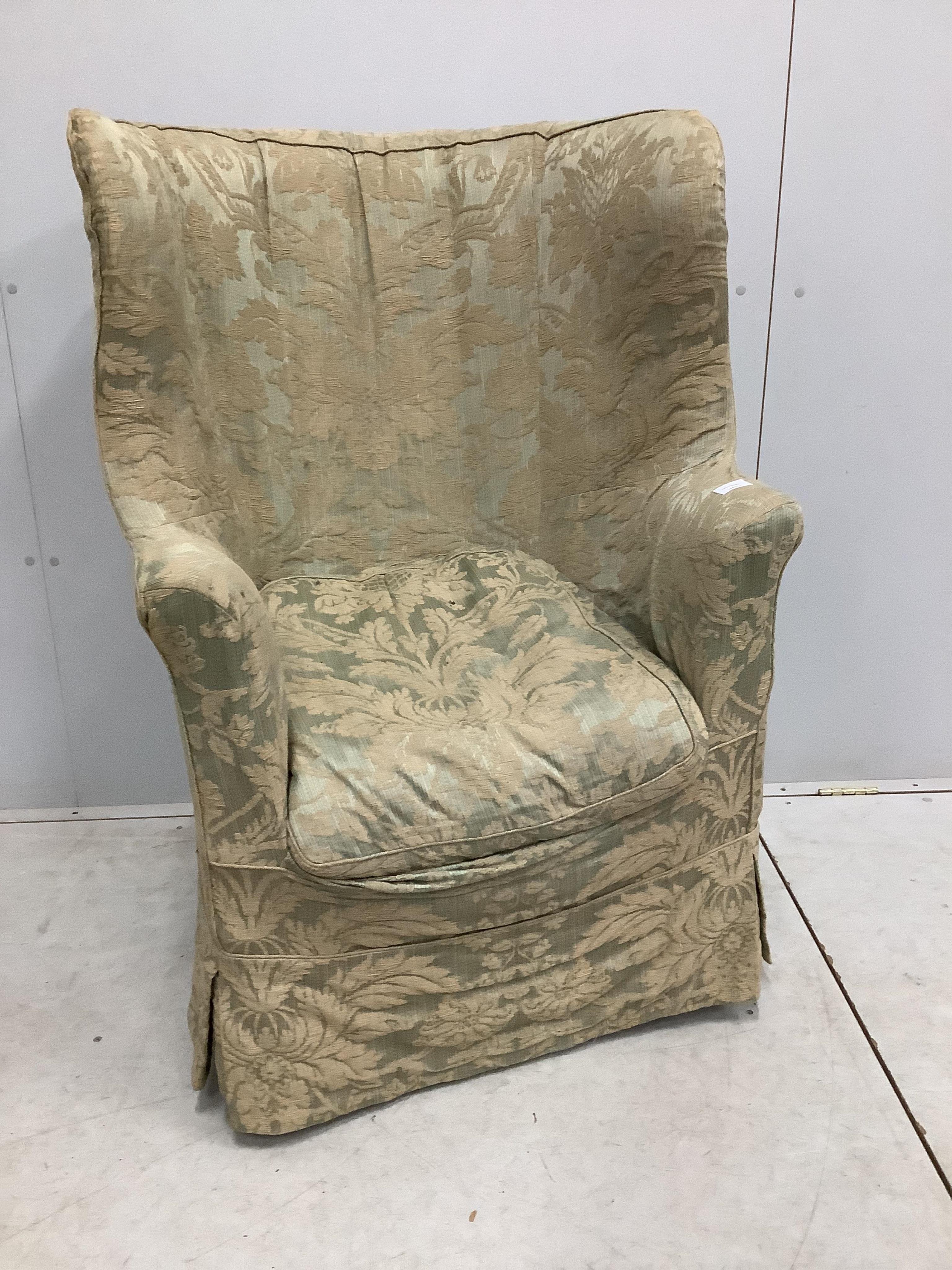 An early 19th century upholstered tub framed wing armchair, width 73cm, depth 55cm, height 113cm. Condition - fair